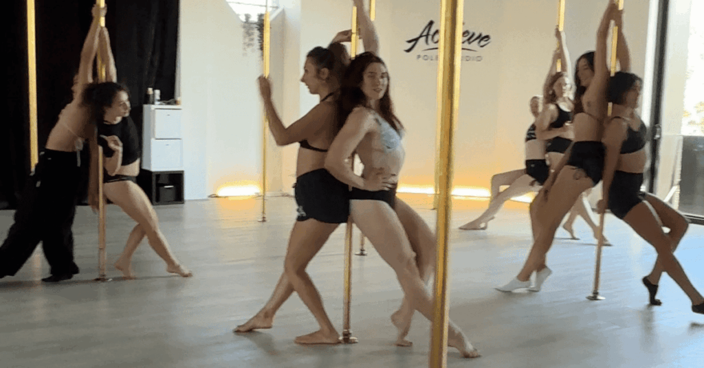 Student focused mid-move during a beginner pole class at Achieve Pole Studio in Rosebery, Sydney.
